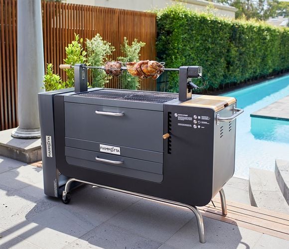 Rotisserie meat being cooked by a pool