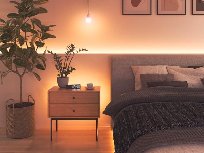 Smart colour changing bulbs and light strips in a bedroom.