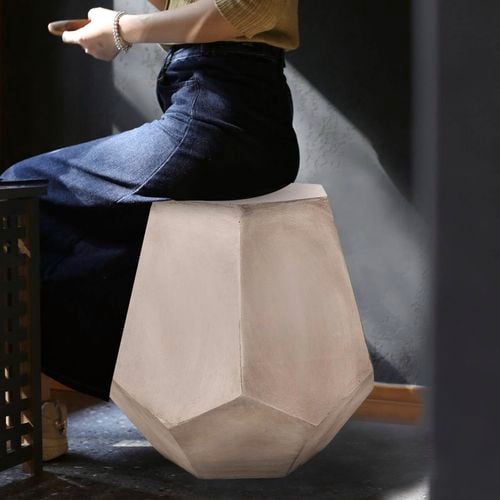 A sculptural geometric side table adds artistic flair and modern function to any room.