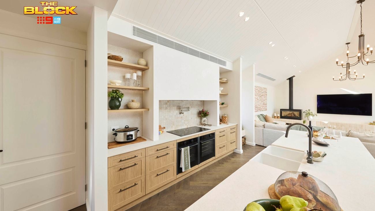 Kitchen with wood cabinetry, open shelves, long island, and living area view.