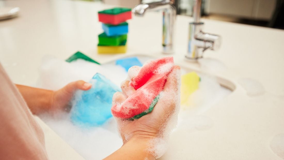 Person using scourer to clean dishes