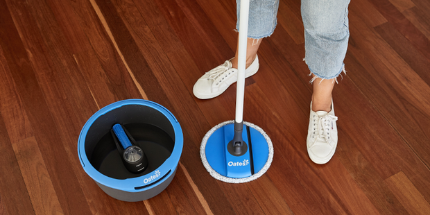 Mop and bucket on wooden floor. 