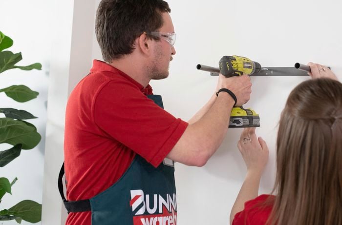 Bunnings team members mounting floating shelf supports