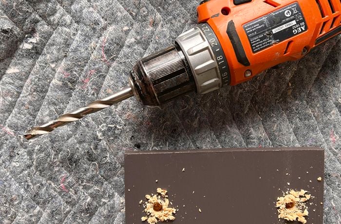 Two holes drilled into pine