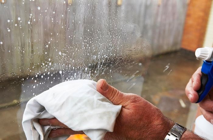 A person cleaning a window with a cloth