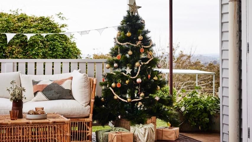 A decorated Christmas tree in a verandah.