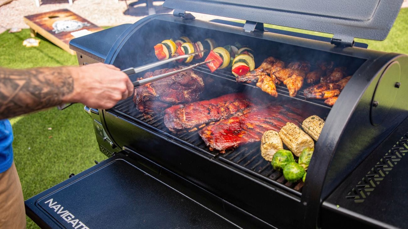 Man turning food with tongs on Pit Boss BBQ