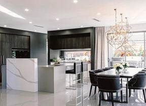 A modern kitchen and dining area with a dining table, curtains, pendant lights.
