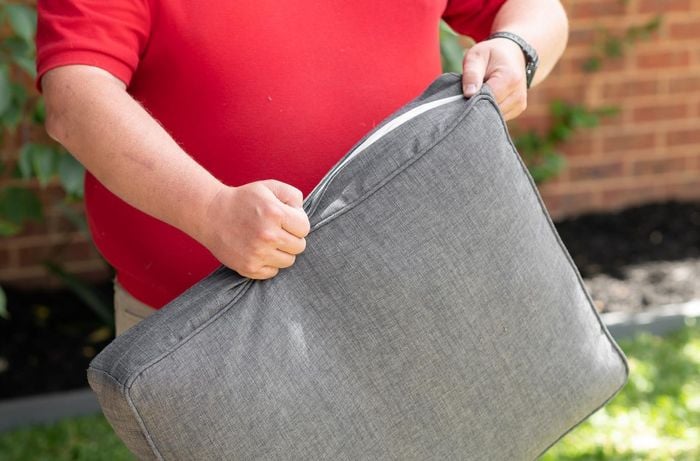TM taking the cover off an outdoor cushion