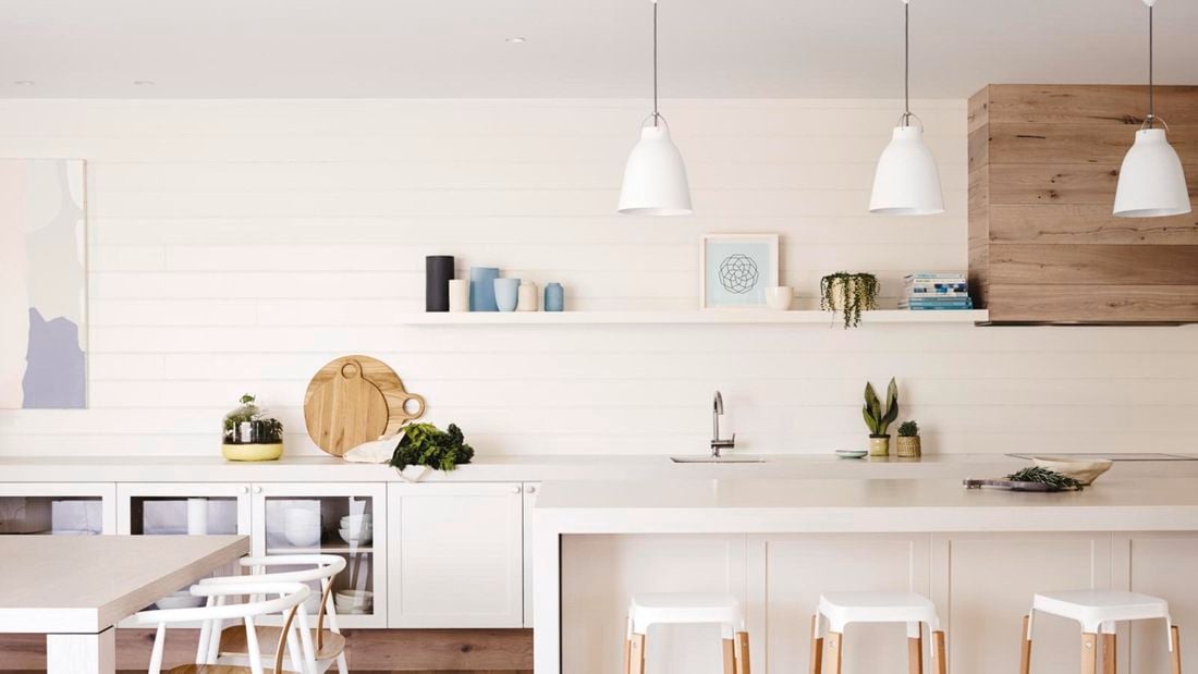 Spacious modern white kitchen with drop down lighting.