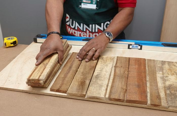 Person laying out timber slats on a workbench