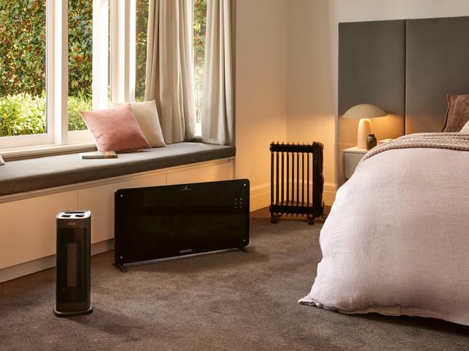 A modern furnished bedroom with multiple heaters in it and carpet on the floor.