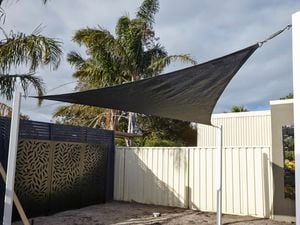 A backyard with a shade sail.