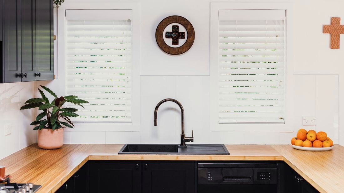 Tap in the kitchen with wooden deco on wall