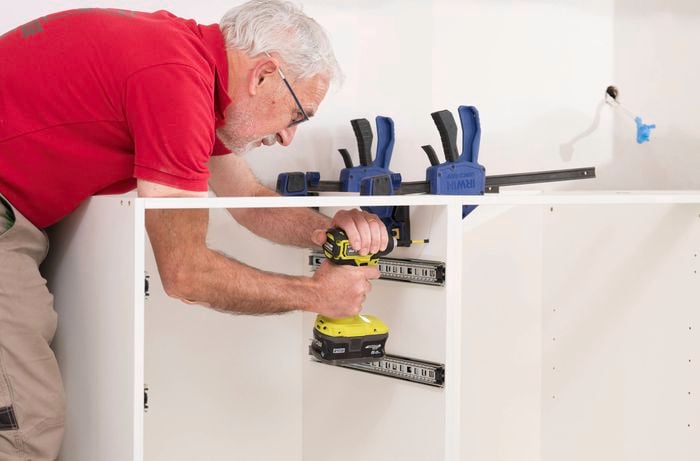 Move the cabinet into place using a power drill