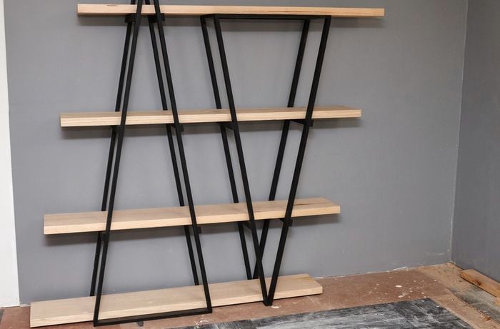 DIY industrial wooden bookshelf against a grey wall.