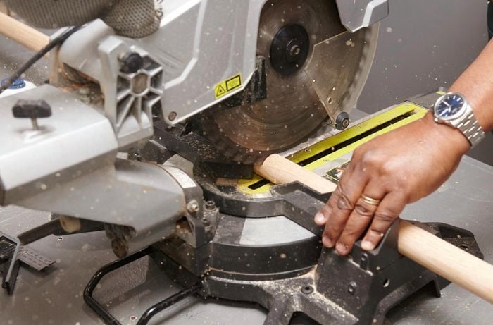 A mitre saw cutting a bar stool leg from a length of dowel
