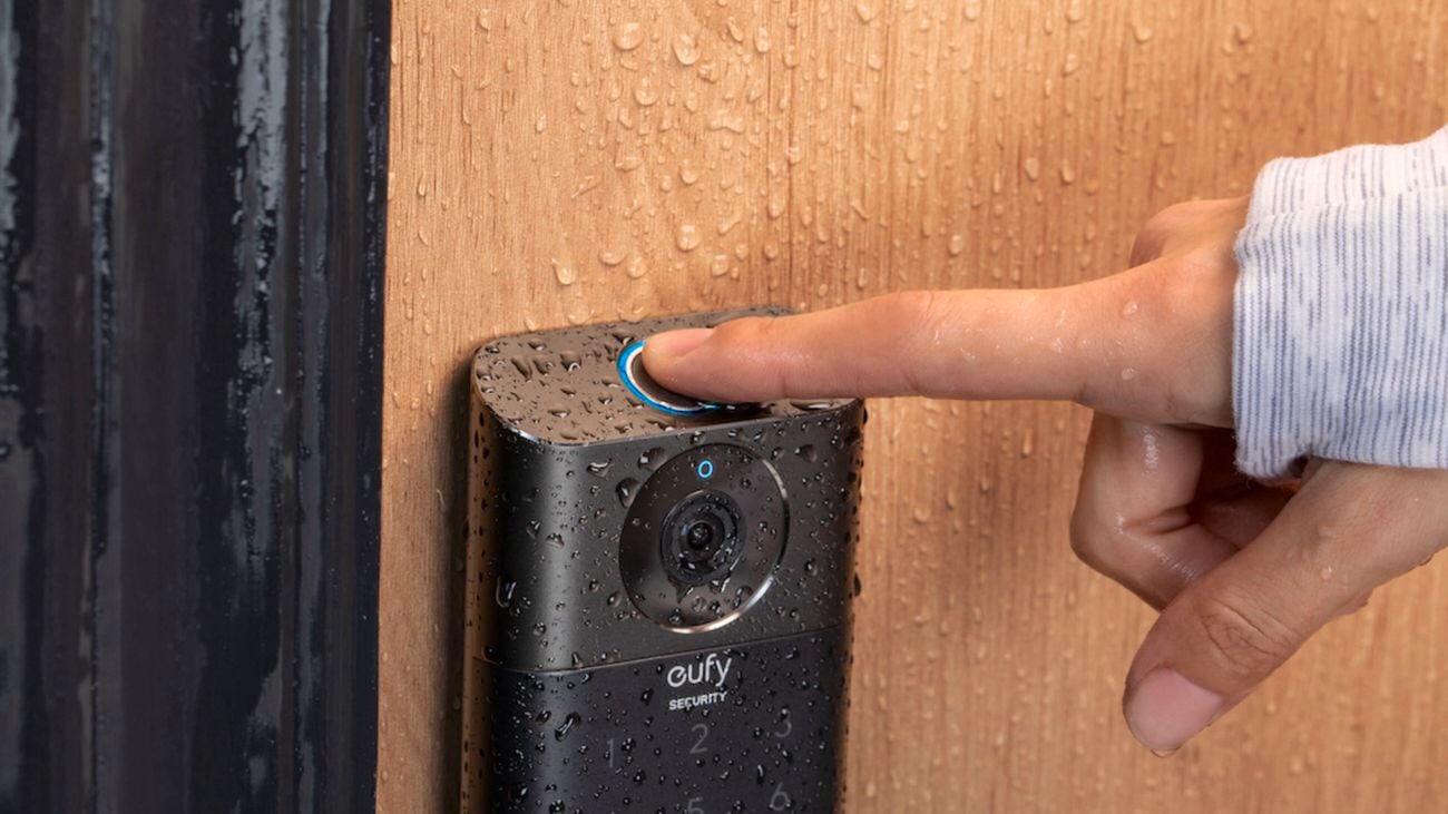 eufy video security lock in the rain with a finger on the top button.