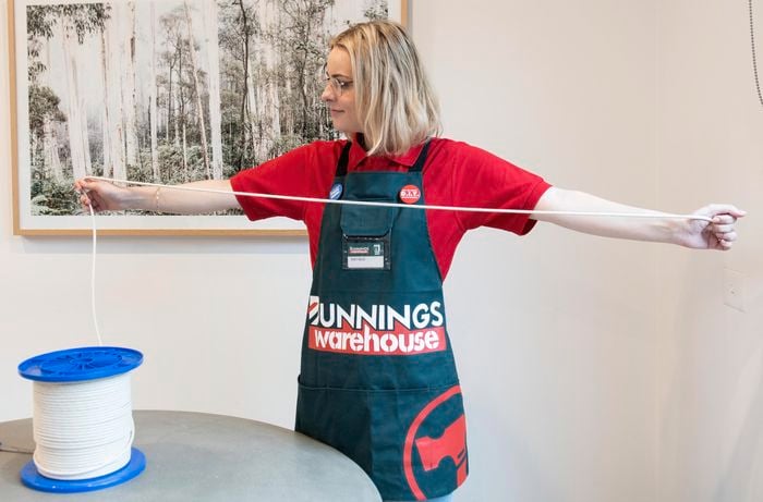 A Bunnings team member spooling out lengths of macrame cord