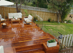 Back garden with timber decking showcasing glass fencing and lounge