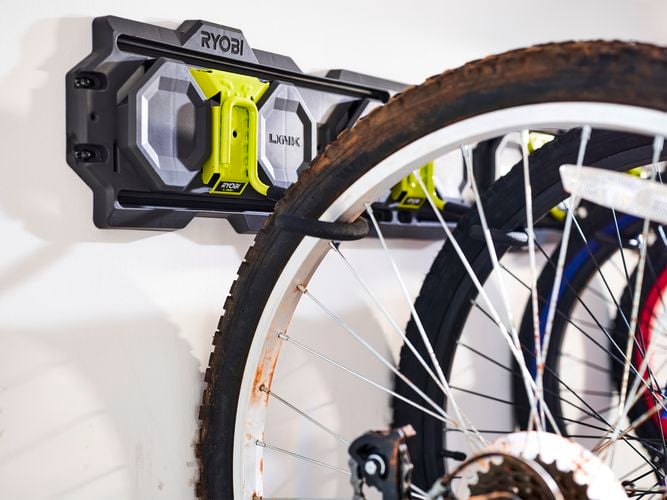 A bike wheel hanging off a metal hook.
