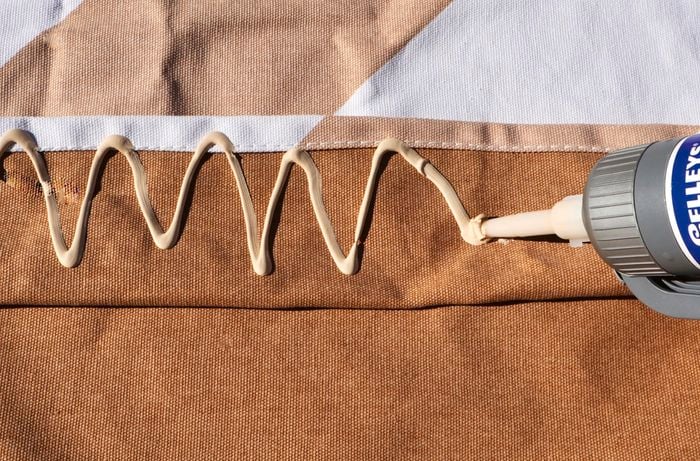 Construction adhesive is applied to hammock fabric in a zigzag pattern