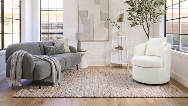 A stylish grey sofa alongside a white armchair in a well-decorated living room.