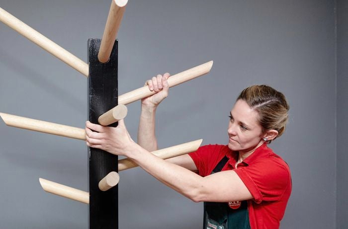 Coat hooks being fitted into the upright post of a coat rack