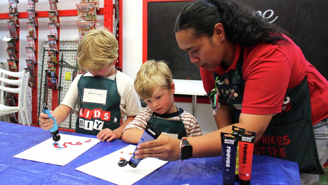 Bunnings team member and children painting.