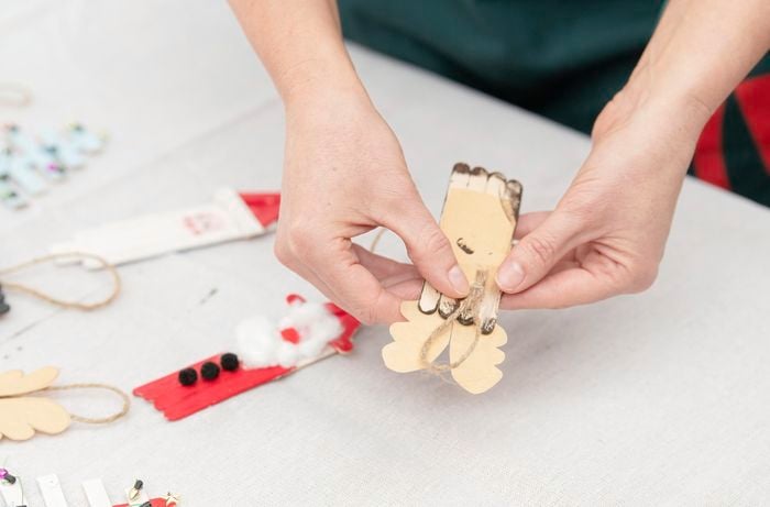 Attaching twine on the back of a handmade decoration so that it can be hung on a Christmas tree