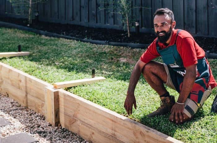 A Bunnings team member with a finished retainer wall