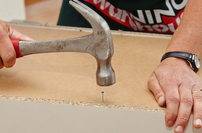 Hammering on a nail on the back panel