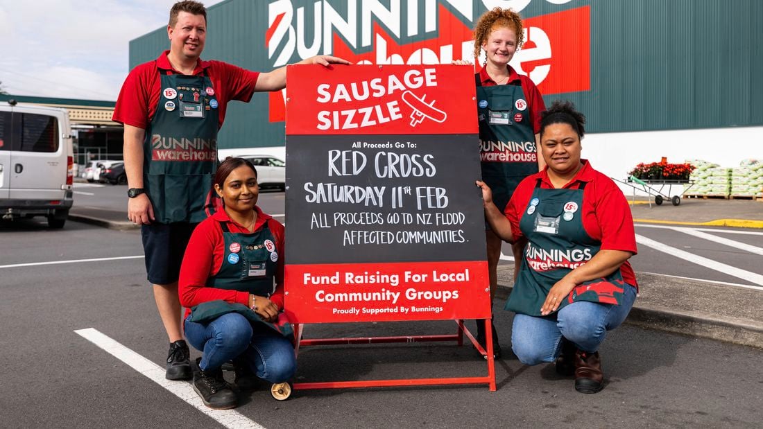 Bunnings TM's with a backboard promoting fundraisginfor Red cross out the front of a Bunnings store.
