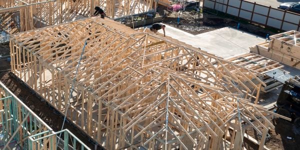 couple of trade person working on timber roofing frames