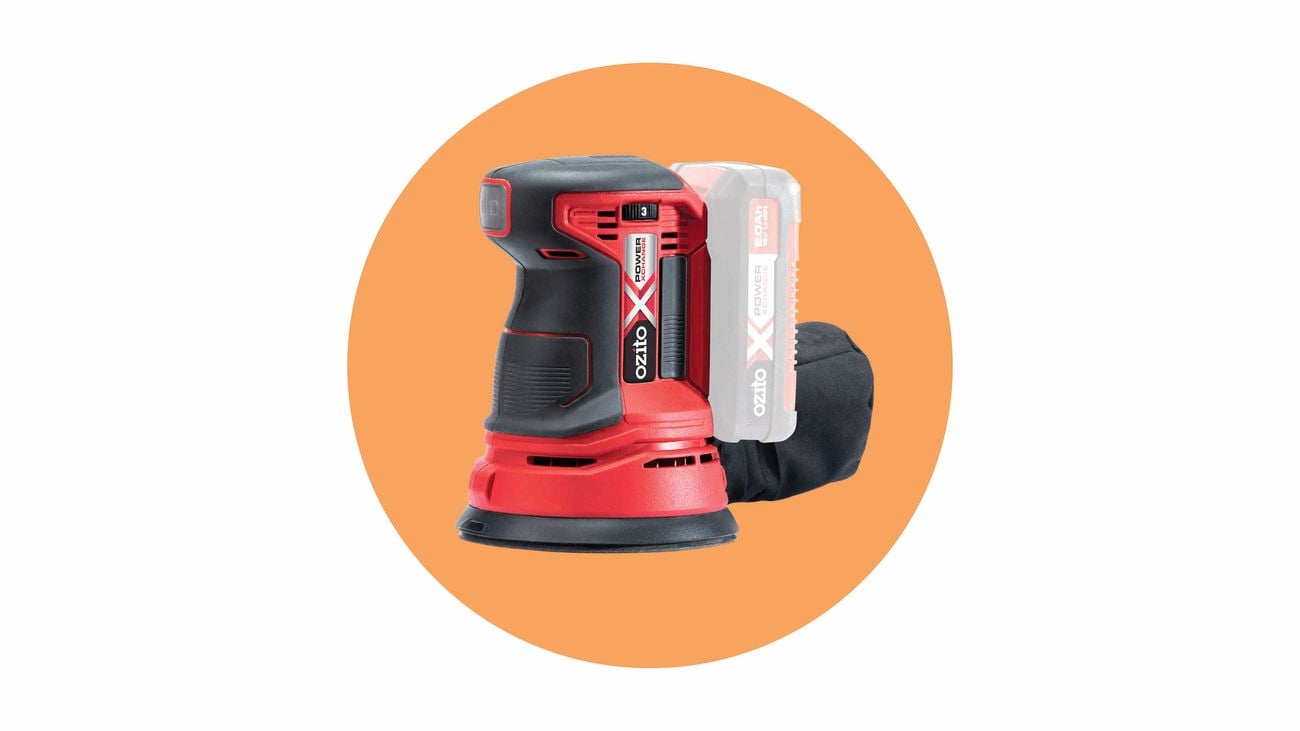 A red and black Ozito orbital sander with a battery pack and dust bag.