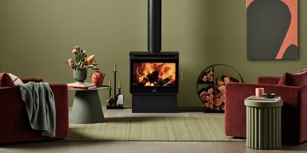 Indoor heater in styled living room with fire going and green tones.