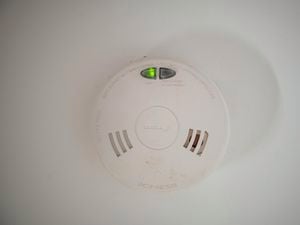 close up of a smoke alarm on a wall