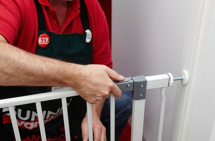 A person fitting a child security gate