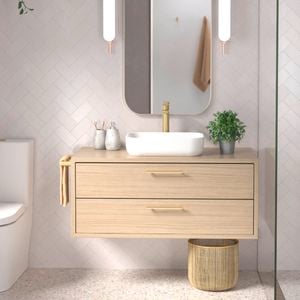 A bathroom with a sink on top of a wooden cabinet, a mirror on the wall and a toilet