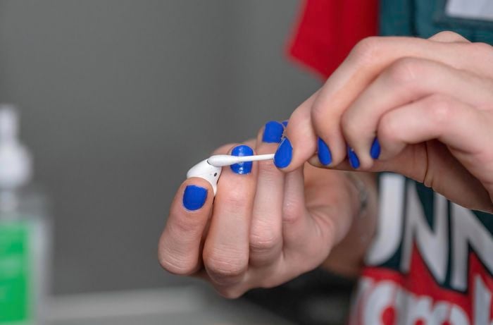 Showing dirt in airpods using cotton swab.