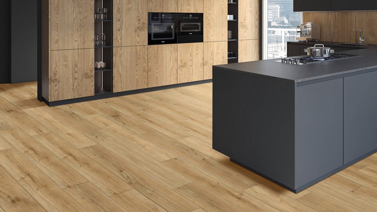 A timber finished kitchen, with black appliances and charcoal benchtop and island cupboards and hard timber floor boards.