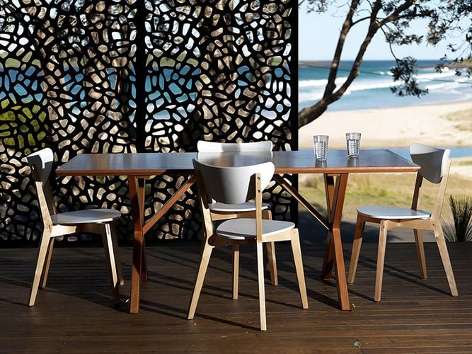 Outdoor timber decking area with dining table and decorative screen adding privacy