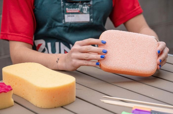 Woman choosing from different sponges.