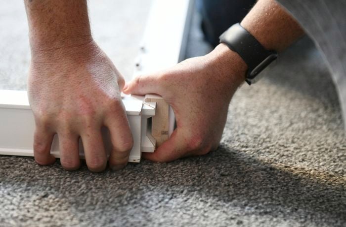 Person assembling a shutter frame on the floor
