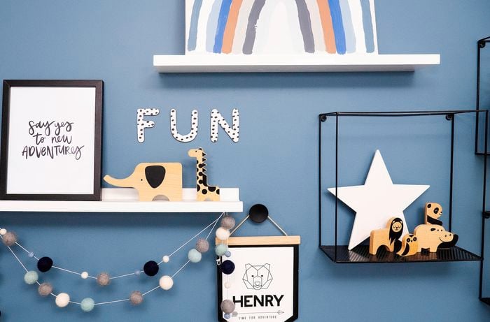 Blue wall with floating shelves and animal decorations.