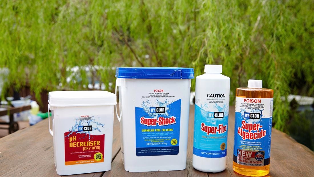 Containers of dry acid, granular pool chlorine, flocculent and algaecide, substances used to treat pool water