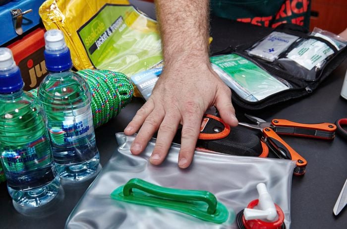 Various things that belong in an earthquake kit, including bottled water, rope, a first aid kit, flashlight, Swiss army tool, sealable bag and more