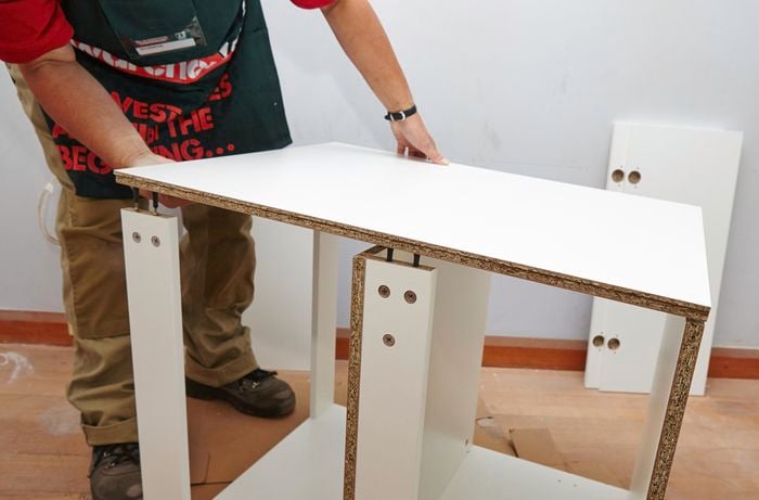 Person attaching side panels to rails