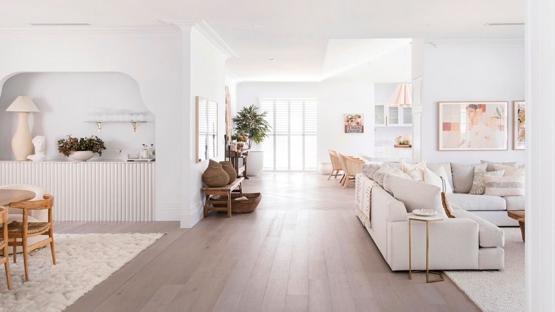 Hampton style home, inside with timber floors, white walls  and cream lounge suit