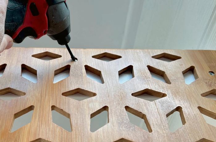 A drill is used to place holes at the top of the timber.